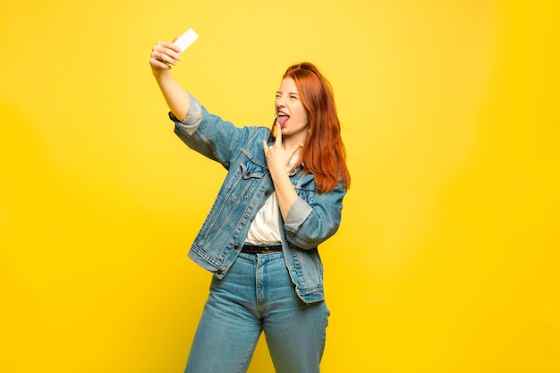 Need minimum clothes for selfie. Caucasian woman's portrait on yellow space