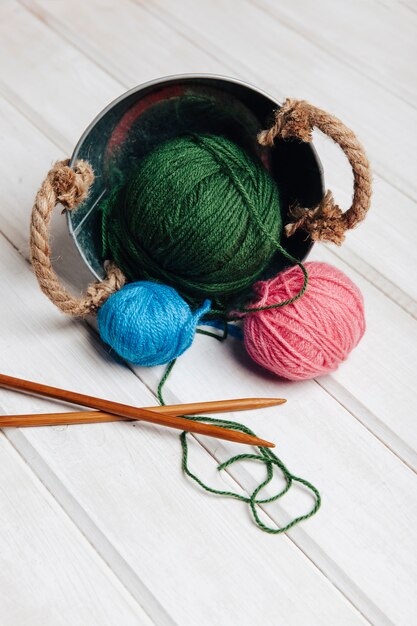 Needles and wool balls in metal pot