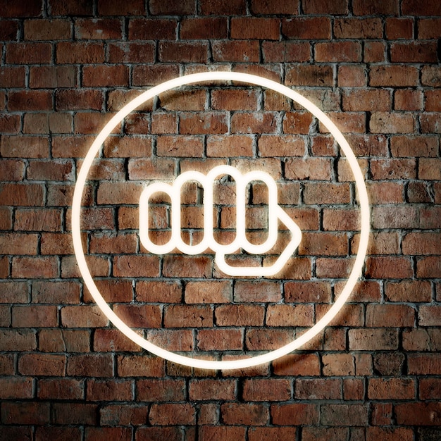 Free photo neon fist in a round frame on a brick wall