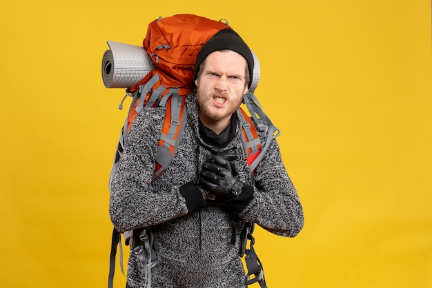 Free photo nervous male hitchhiker with leather gloves and backpack showing punches