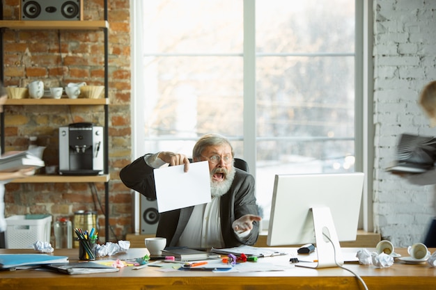 Free Photo nervous and tired boss at his workplace busy while people moving near blurred. office worker, manager working, has problems and deadline, his colleagues distracting. business, work, workload concept.