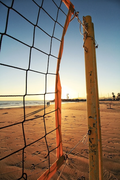 Free Photo net of volleyball on the beach and the sunset seen in the blurred background