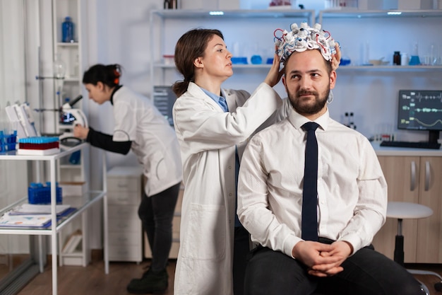 Free photo neurologist doctor analysing brain of man and nervous system using brainwave scanning headset. researcher using high tech developing neurological innovation monitoring side effects on monitor screen