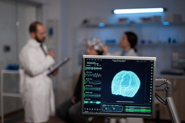 Free photo neuroscience doctor holding clipboard showing treatment against brain disease to patient with eeg headset. woman sitting in neurological scientific laboratory treating nervous system dysfunctions.