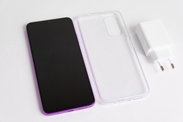 New cellphone and charger with transparent cover over isolated white background