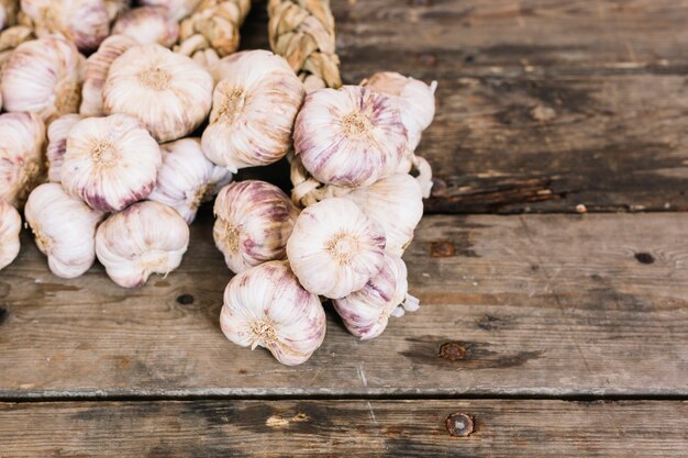 New harvest big violet garlic braid on wooden background