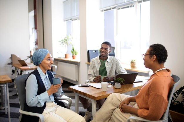 New male employee conversing with female colleagues at his new office job