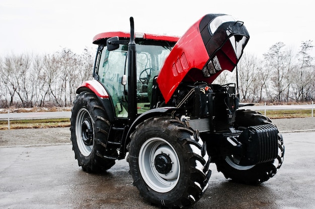 Free photo new red tractor with open motor at snowy weather