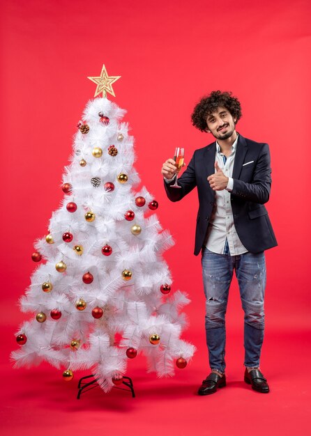 New year celebration with bearded young man holding a glass of wine making ok gesture