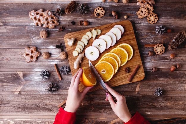 New Year and Christmas preparations. Look from above at woman slicing fruits f