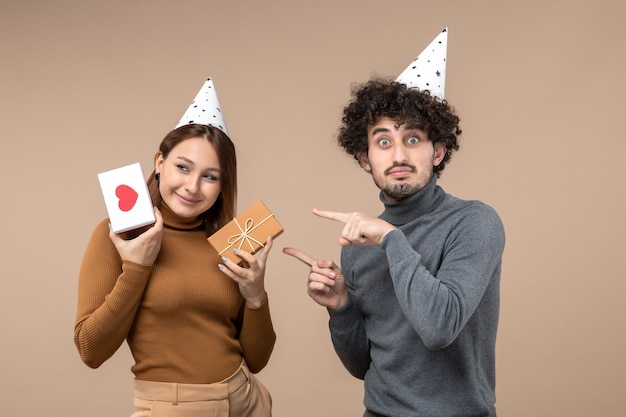 New year concept with beautiful young couple wear new year hat emotional girl