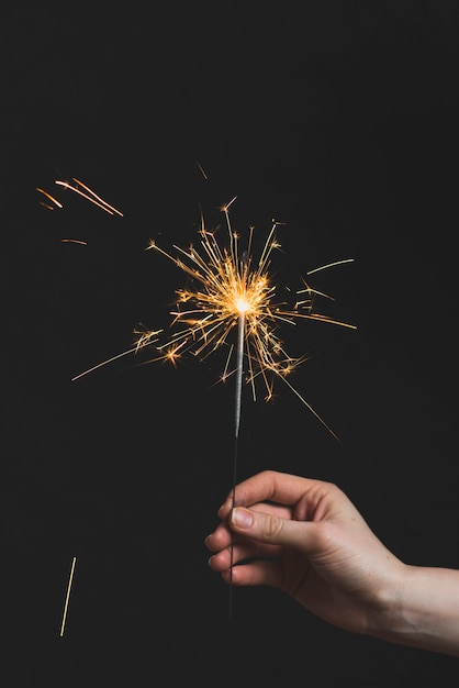 Free photo new year concept with hand holding sparkler