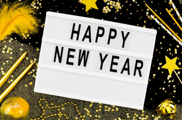 Free Photo new year lettering on a white card with golden accessories