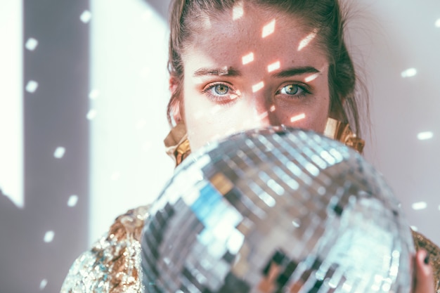 Free Photo new year party concept with girl behind disco ball