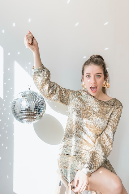 Free Photo new year party concept with girl holding disco ball