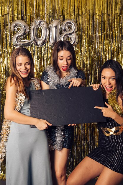 New year party concept with girls pointing at board