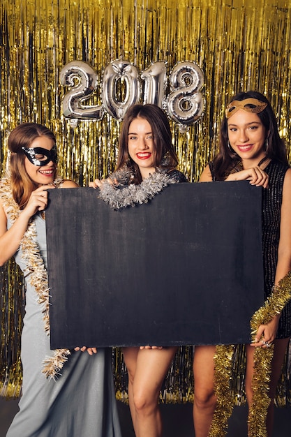 New year party concept with girls showing chalkboard