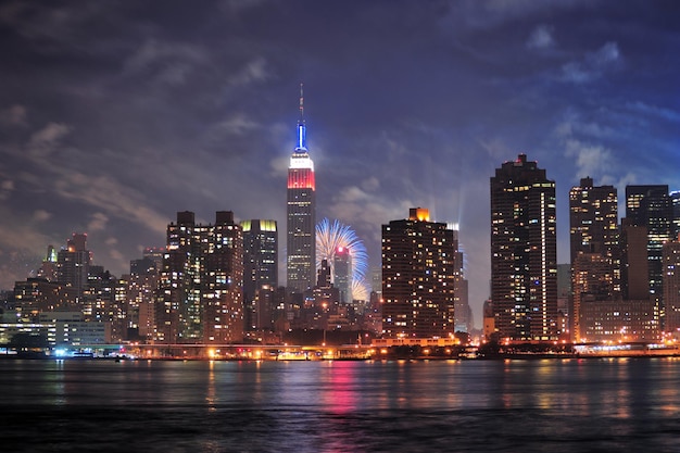 New York City Manhattan midtown panorama at dusk with skyscrapers illuminated over east river