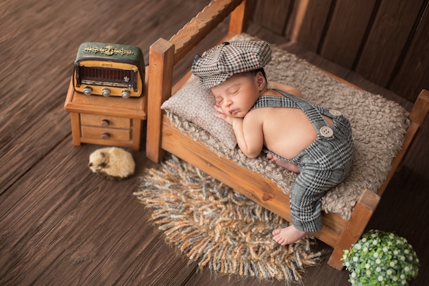 Newborn baby boy sleeping in beautiful room which includes carpet flower radio and cute animal