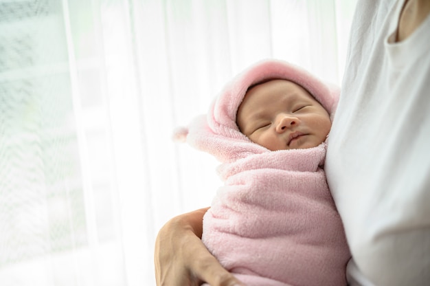 newborn baby sleeping in the embrace of the mother