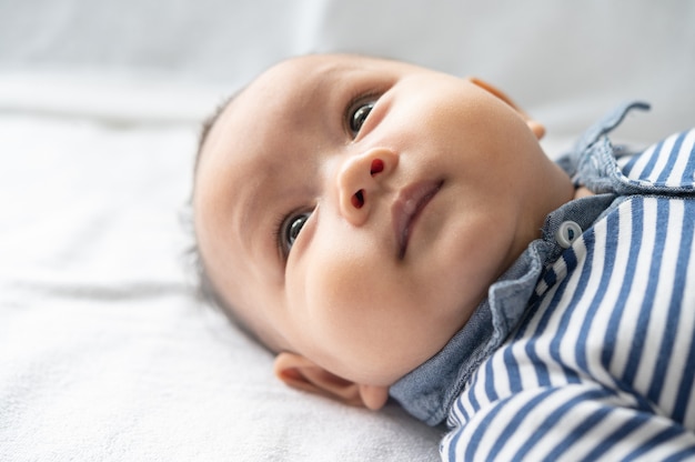 A newborn baby who opens his eyes and looks sideways