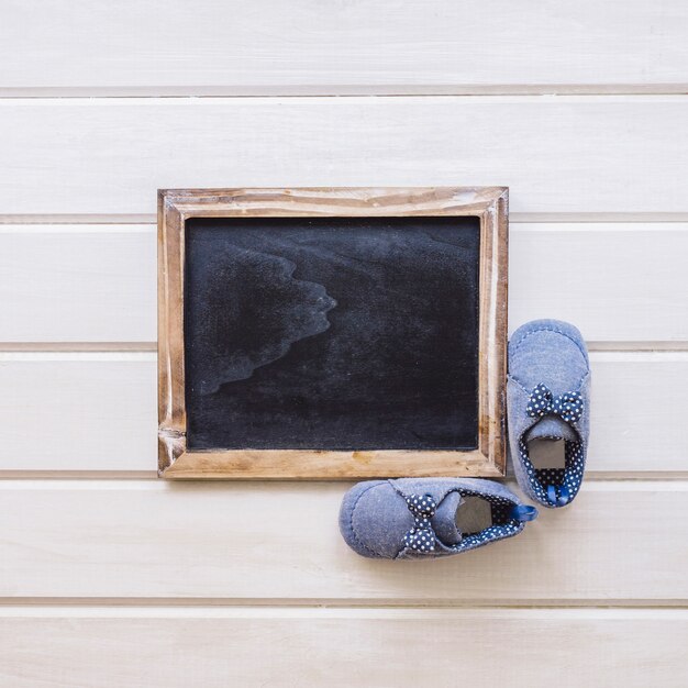 Newborn concept with blank slate en shoes