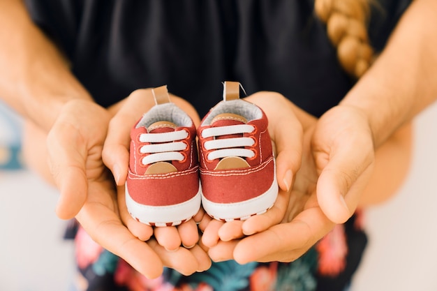 Free photo newborn concept with couple holding shoes in hands