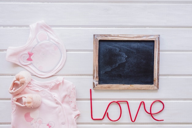 Free Photo newborn concept with slate, clothes and love