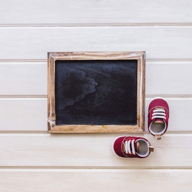 Free photo newborn concept with small shoes and slate