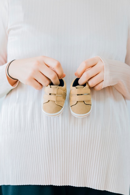 Newborn concept with woman holding shoes