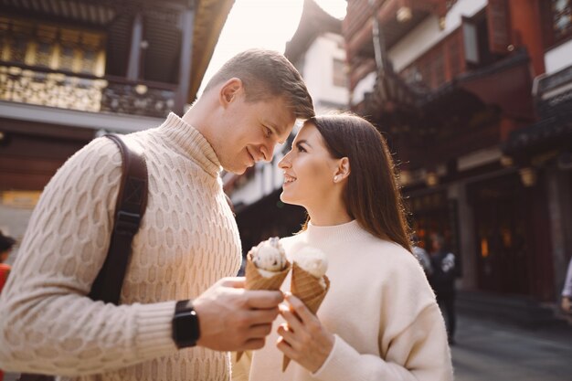 Newlywed couple eating ice cream from a cone on a street in Shanghai near Yuyuan China.