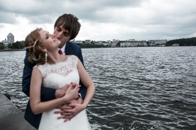 Newlyweds kissing with beautiful landscape background