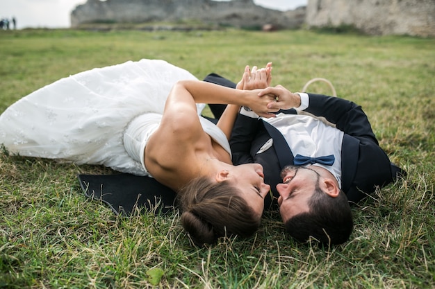 Newlyweds in love lying on the grass