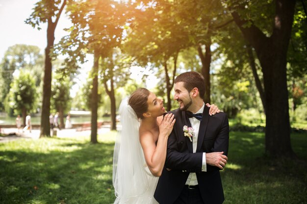 Newlyweds smiling in the park