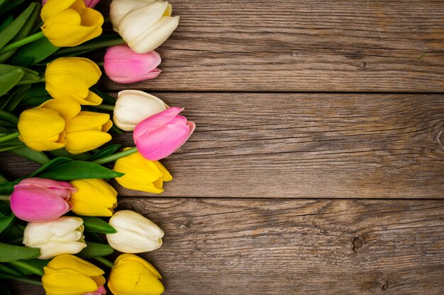 Nice composition with tulips with copy space on wooden