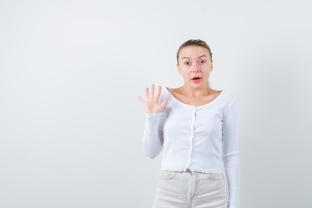 Noble blonde girl is showing her hand on white background