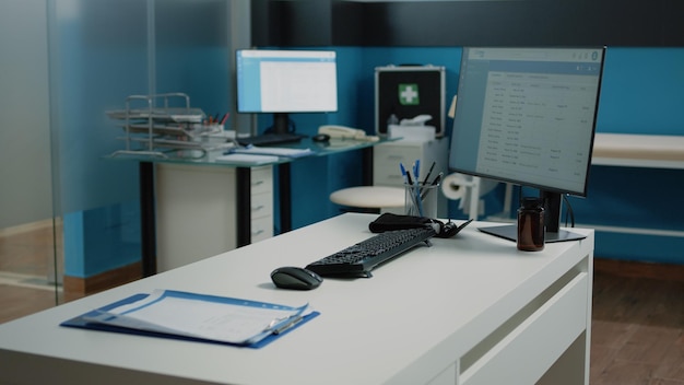 Free photo nobody in cabinet with medical equipment for checkup visit and examination. close up of desk with computer, documents and tools for consultation in empty doctors office at facility.