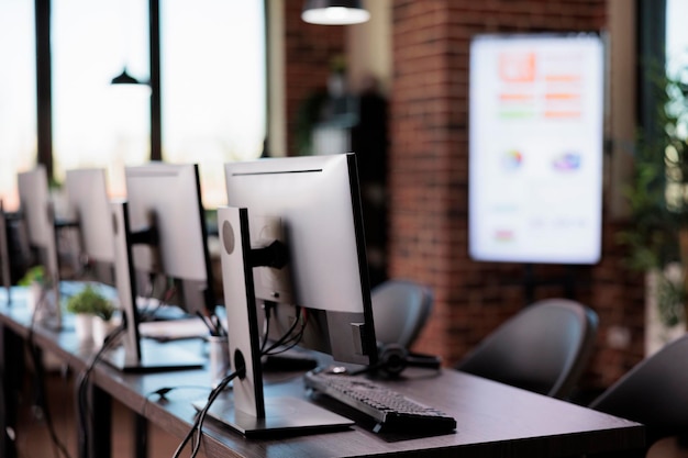 Nobody in office with multiple monitors at customer service desk, call center helpline support to give telecommunication assistance. Empty helpdesk with client telephony reception.