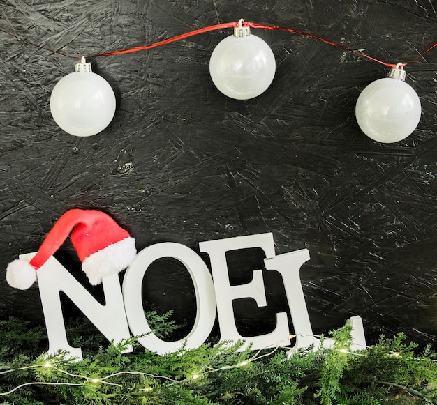 Noel inscription with shiny baubles 