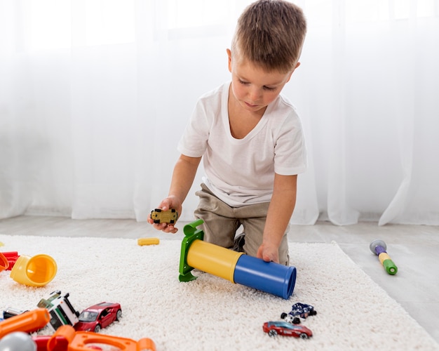 Free photo non binary kid playing with a car game