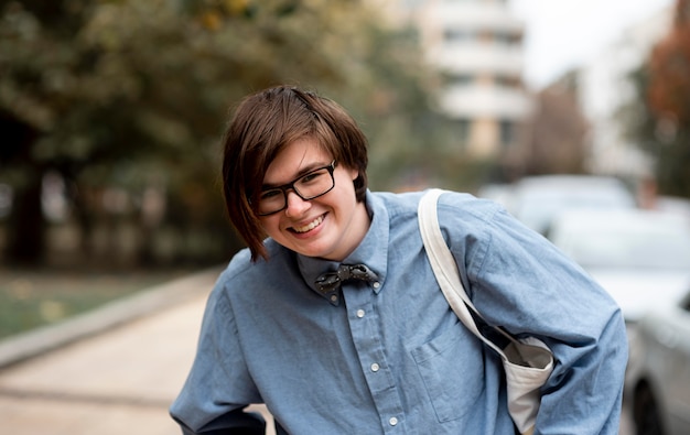 Non binary person with glasses smiling