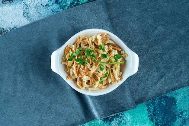 Free Photo noodle in a bowl on a pieces of fabric , on the blue table. 