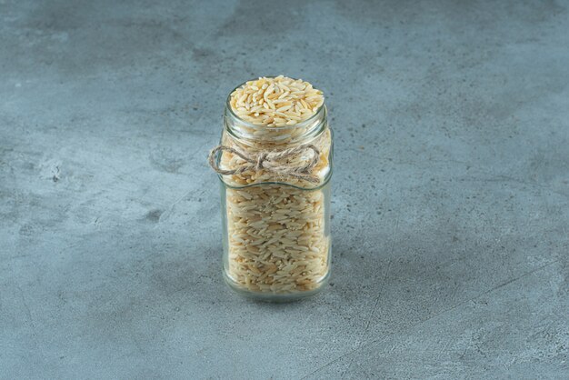 Noodle grains in a glass jar on blue background. High quality photo