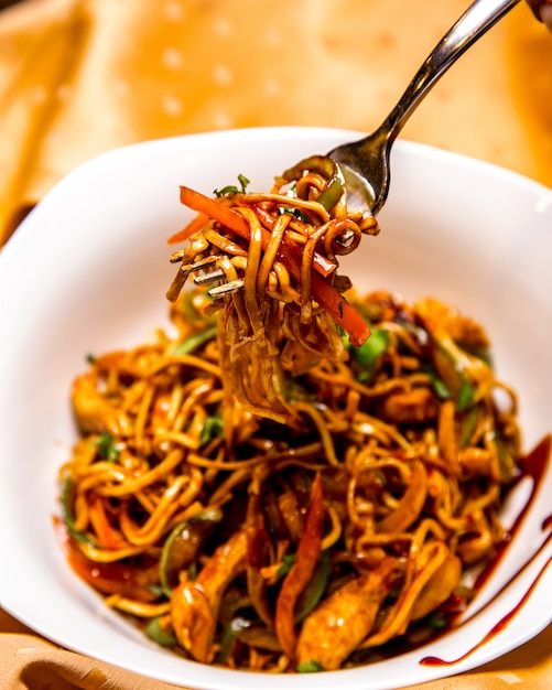 Noodle with chicken in a bowl side view