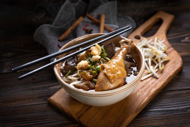 Noodles with chicken leg and chicken fillet, blood with soup Thai style and vegetable. Boat Noodles. Selective focus