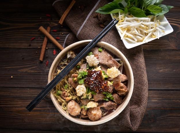 Free photo noodles with pork and pork balls, chilli paste with soup thai style and vegetable. boat noodles. selective focus. top view