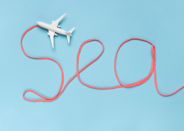 Free photo note sea made of cotton and small white airplane