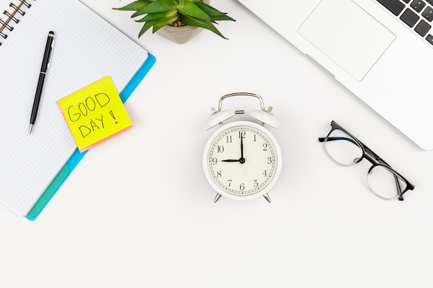 Free photo notebook an alarm clock laptop and a paper reminder on a white background