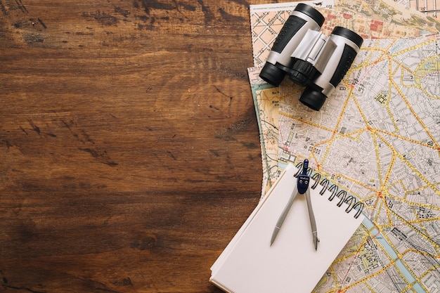 Notebook an compasses near binoculars and maps