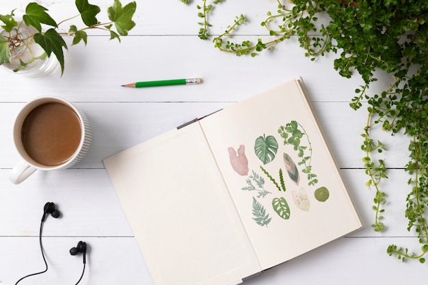 Free Photo notebook flat lay in plants with hand drawn illustrations